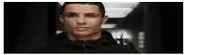 a close up of a man 's face in a dark hallway looking at the camera .