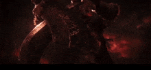 a large demon with horns is flying through the air in a dark room .