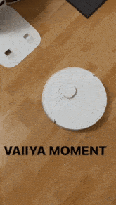 a robotic vacuum cleaner is on a wooden floor with the words vaiiya moment below it