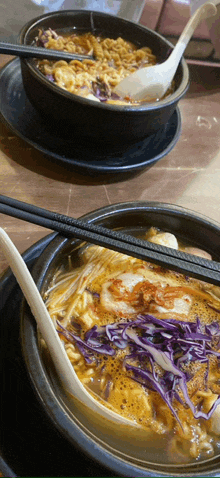 two bowls of soup with chopsticks and spoons