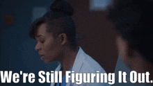 a woman in a lab coat with the words we 're still figuring it out below her