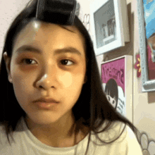 a girl with a roller in her hair is looking at the camera
