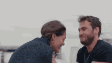 a man and a woman are looking into each other 's eyes .