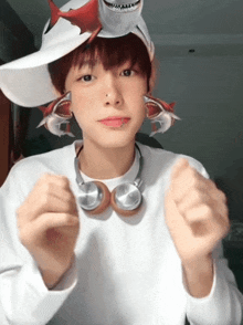 a boy wearing headphones and a shark hat