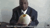 a man in a suit and tie is holding a melon with a hole in it and says this shit will have you screaming