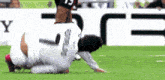 a soccer player with the number 13 on his jersey is laying on the ground
