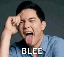 a man is sticking his tongue out and making a funny face while holding his hand to his forehead .