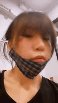 a woman wearing a black shirt and a black mask on her face