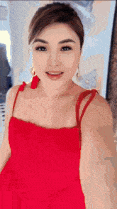 a woman in a red dress is smiling in front of a mirror
