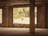 an empty room with a window and a yellow pole