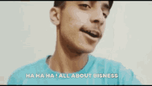 a young man in a blue shirt is making a funny face and saying `` all about bisness '' .