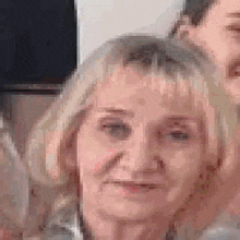 a close up of a woman 's face with a blurry background and a man in the background .