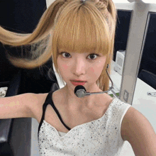 a woman with blonde hair and a microphone on her neck