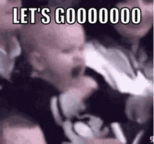 a baby is screaming in a crowd of people with the words `` let 's gooooooo '' written on it .