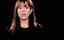 a young woman is making a face with her hands .