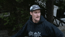 a man wearing a hat and a hoodie has the word incest on his shirt