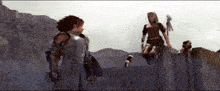 a group of people are standing on top of a stone wall