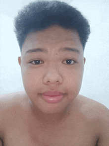 a shirtless young man looks at the camera with a serious look on his face