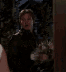 a man is holding a bouquet of flowers in his hand .