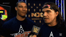 two wrestlers are being interviewed by a woman in front of a sign that says wwe nxt