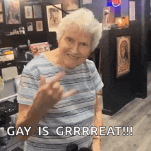 an elderly woman giving a peace sign with the words gay is grrrreat !! below her