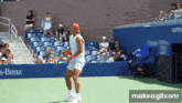 a man playing tennis in front of a emirates airline advertisement