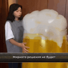 a woman is holding a large inflatable beer glass with a foamy head