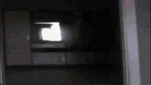 a black and white photo of a dark room with a window