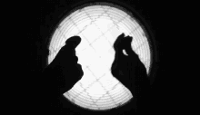 a person 's hands are silhouetted against a white background