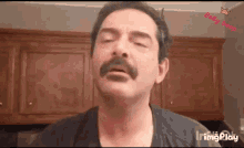 a man with a mustache is making a funny face with his eyes closed ..