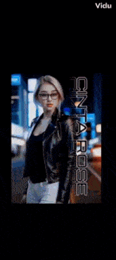 a woman wearing glasses and a leather jacket is standing in front of a street at night .