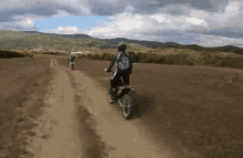 a person riding a dirt bike on a dirt path