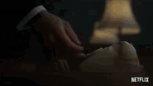 a close up of a person 's hand pressing a button on a desk .