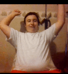 a man in a white shirt with his arms up