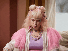a woman with pink hair and a necklace with butterflies on it