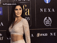 a woman is standing in front of a wall with logos on it .