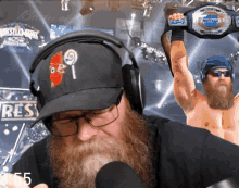 a man with a beard is wearing headphones and holding a wrestling championship