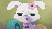 a cartoon rabbit with a flower on its head is sitting next to a green egg .