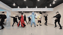 a group of people in costumes are dancing in a dance studio .