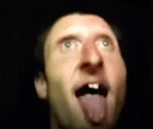 a close up of a man 's face with his tongue sticking out .