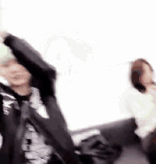 a blurry picture of a woman sitting on a couch .