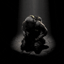 a soldier is kneeling down in the dark