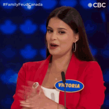 a woman in a red jacket with the name victoria on her shirt