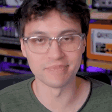 a man wearing glasses and a green shirt is smiling for the camera