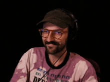 a man wearing glasses and headphones is wearing a pink shirt that says ' i 'm a citizen '