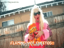 a woman is holding a bag of flaming hot chips