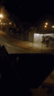 a blurry picture of a street at night with a few lights visible