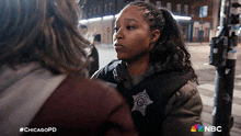 a woman in a chicago police uniform is talking to another person