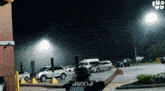a person standing in a parking lot with a sign that says ' iu tv ' on it