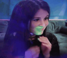 a woman with a green circle on her face is smiling